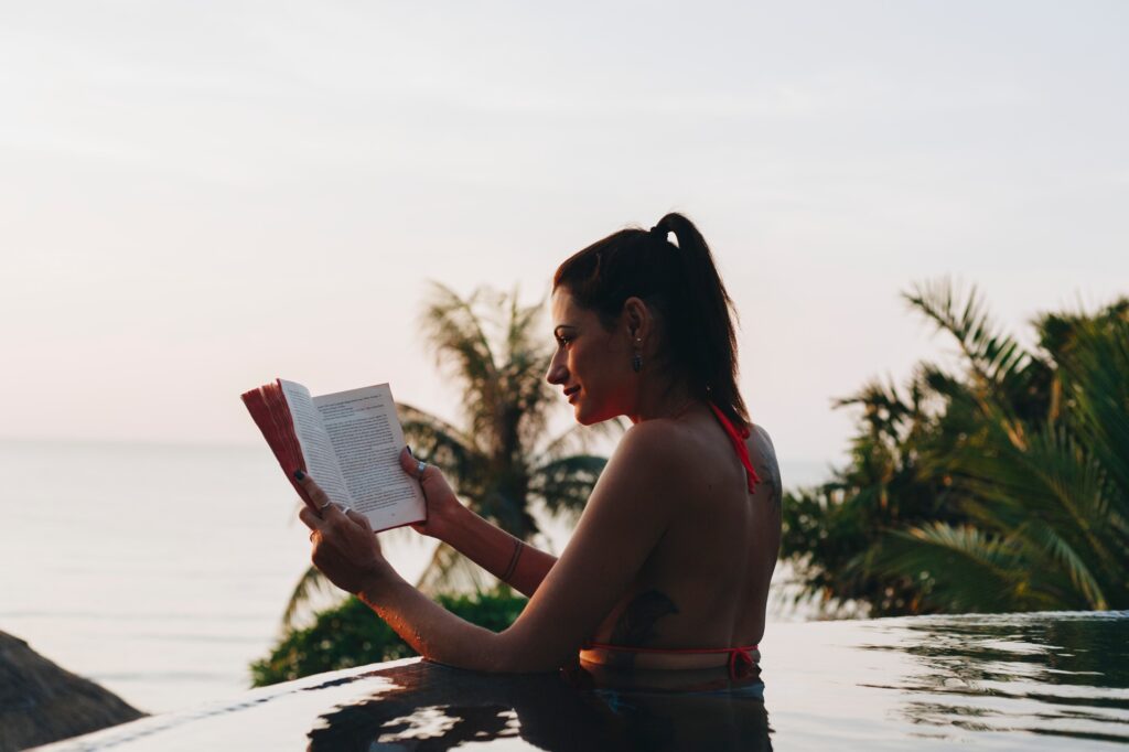 woman reading a book in the swimming pool